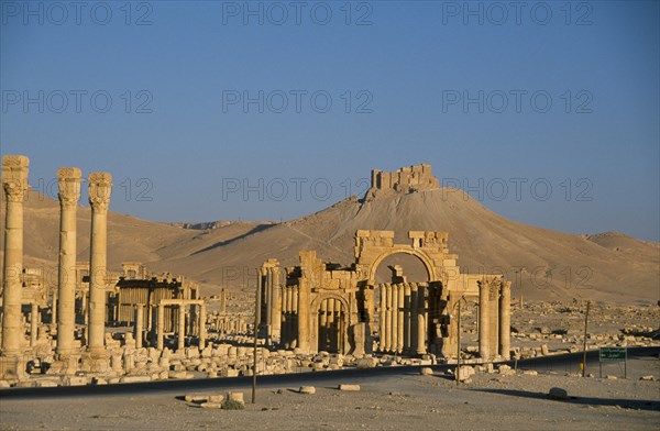 SYRIA, Central, Tadmur, View towards Monumental Arch comprising of high central arch flanked by a lower arch on each side with the Arab Castle or Qalaat Ibn Maan on the hilltop behind.