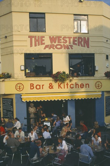 ENGLAND, East Sussex , Brighton, City bar and restaurant with open front and people sitting at crowded outside tables.