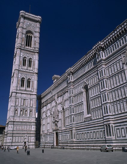 ITALY, Tuscany, Florence, "The Duomo.  Exterior wall and the Campanile, designed by Giotto in 1334 and clad in white, pink and green Tuscan marble."