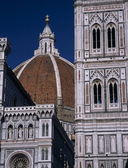 ITALY, Tuscany, Florence, The Duomo. Part view of the dome seen between the Campanile and facade from ground level.