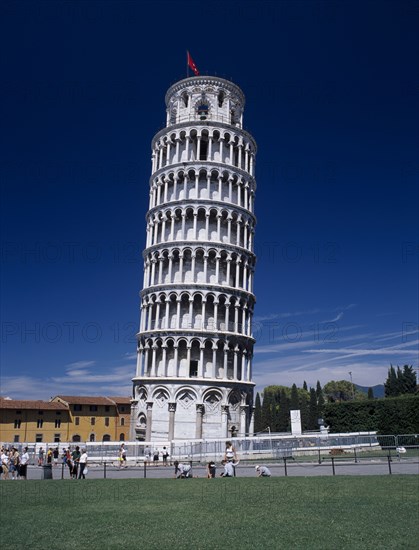 ITALY, Tuscany, Pisa, The Leaning Tower with barriers around base while restoration work is carried out and visitors in surrounding area.