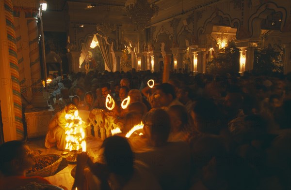 INDIA, Utter Pradesh, Vrindaven, "Dirwali festival, crowds of worshippers holding lighted candles in dark temple interior.  "