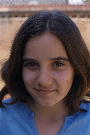 CHILDREN, Girls, Single, Portrait of smiling girl with brown hair and eyes wearing a blue top.