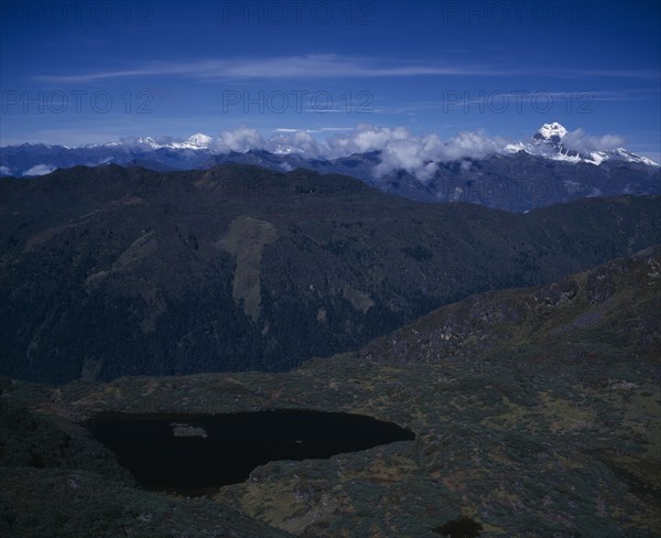 BHUTAN, Simkota Tsho, "View from above towards mountain peak of Jitchu Drakey 6989 metres above sea level, in drifting cloud."