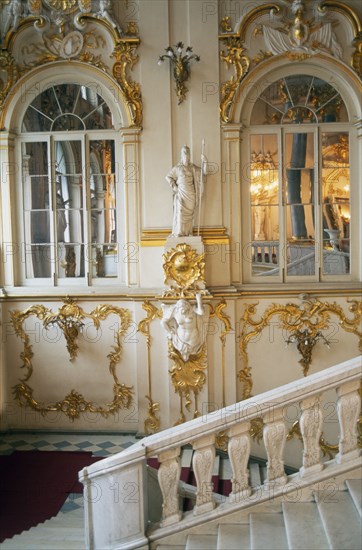 RUSSIA, St Petersburg, The Winter Palace of the Hermitage Museum.  Interior with detail of  the Jordan Staircase and walls with gold leaf and plaster motifs reflected in arched mirrors.