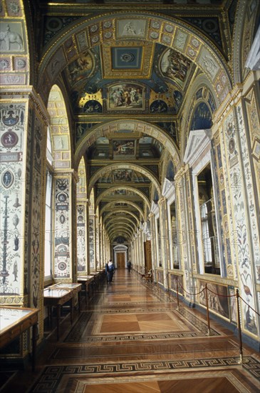 RUSSIA, St. Petersburg, Hermitage Museum.  View along loggia displaying paintings by Raphael with visitors at far end.