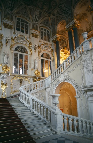 RUSSIA, St. Petersburg, The Winter Palace of the Hermitage Museum.  Detail of the Jordan Staircase and opulent white and gold interior decoration.
