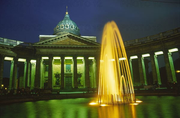 RUSSIA, St. Petersburg, "Kazan Cathedral, exterior facade and fountain in foreground illuminated at night."