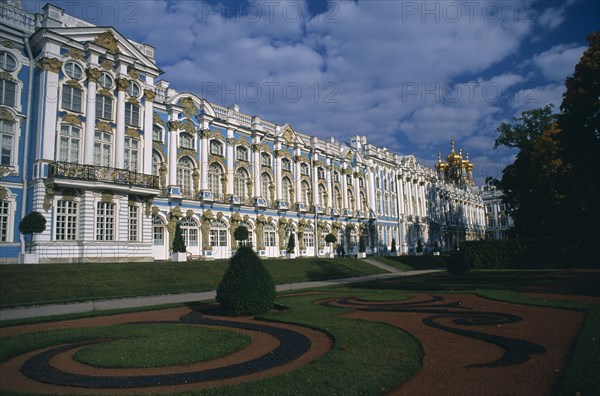 RUSSIA, Pushkin, "Catherine Palace.  View across formal gardens towards blue, white and gold painted exterior. "