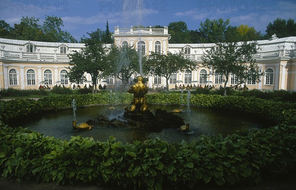 RUSSIA, St. Petersburg, Peterhof Palace grounds. The Orangerie in the lower gardens with circular pond and fountain in the foreground.