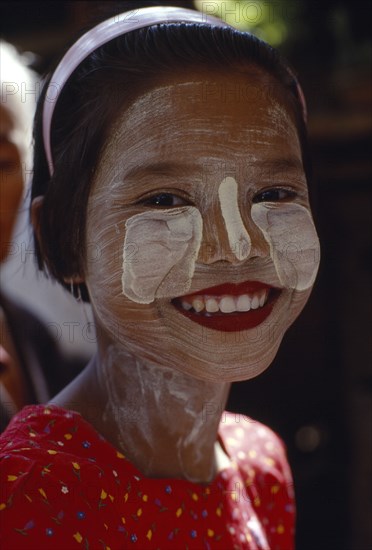 MYANMAR, Children, Single Girls, Smiling young girl wearing thanaka paste on her face in traditional Burmese style.