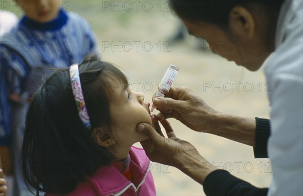 VIETNAM, North, General, Primary school pupil receiving oral polio immunization.