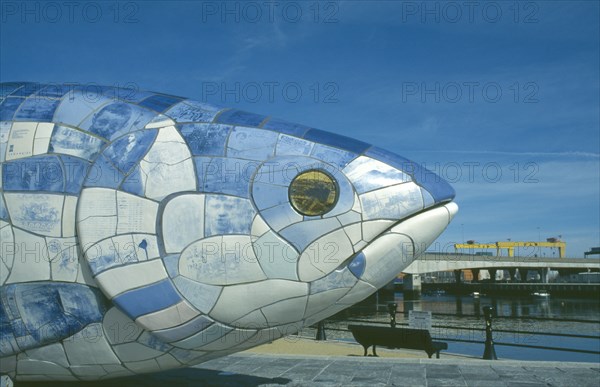 IRELAND, North, Belfast, Sculpture of fish next to Lagan Weir footbridge. Designs use Lasertran photocopies of old newspaper clippings.