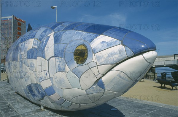 IRELAND, North, Belfast, Sculpture of fish next to Lagan Weir footbridge. Designs use Lasertran photocopies of old newspaper clippings.