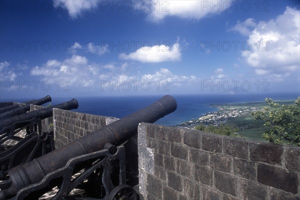 WEST INDIES, St Kitts, Brimstone Hill Fort, View of coastline from the top of the fortified wall with line of cannons.