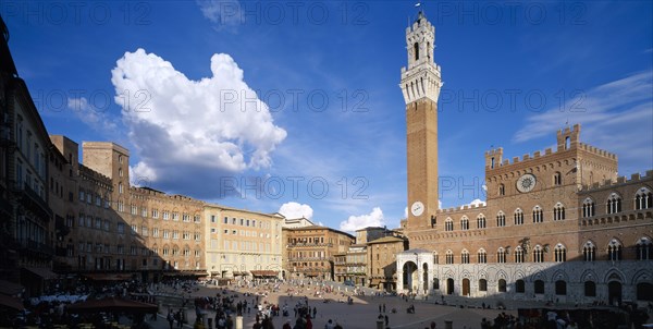 ITALY, Tuscany, Siena, Piazza del Campo.  View across busy piazza lined with bars and cafes and the Palazzo Pubblico Gothic town hall and bell tower completed in 1342.