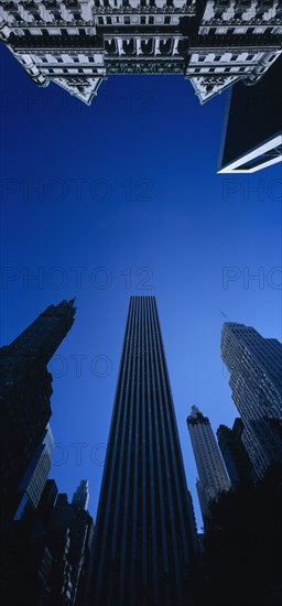 USA, New York State, New York, Midtown architecture seen from below looking upwards against cloudless blue sky.