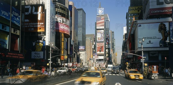 USA, New York, Manhattan, "Times Square.  Daytime view with traffic and advertising hoardings, speeding yellow cabs in the foreground."