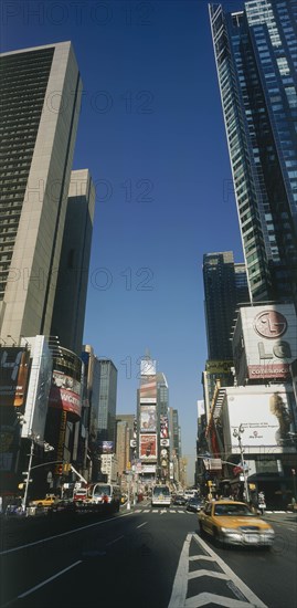 USA, New York, Manhattan, "Times Square.  Daytime view with traffic and advertising hoardings, speeding yellow cabs in the foreground."