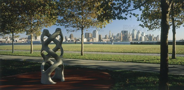 USA, New York State, New York, "Lower Manhattan.  Post September 11 skyline seen from a public park in Hoboken, New Jersey with trees and modern sculpture in the foreground."