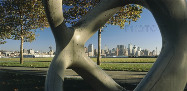USA, New York State, New York, "Lower Manhattan.  Post September 11 skyline seen from a public park in Hoboken, New Jersey part framed by modern sculpture in the foreground."