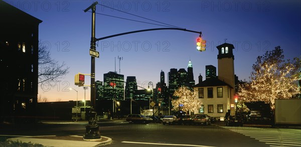 USA, New York, Manhattan, Lower Manhattan.  Post September 11 skyline from Old Fulton Street in Brooklyn at night with pedestrian crossing and traffic lights in the foreground.