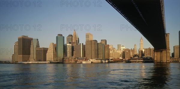 USA, New York State, New York, "Lower Manhattan.  Post September 11 skyline from Brooklyn in warm, golden light with underside of bridge in the foreground."
