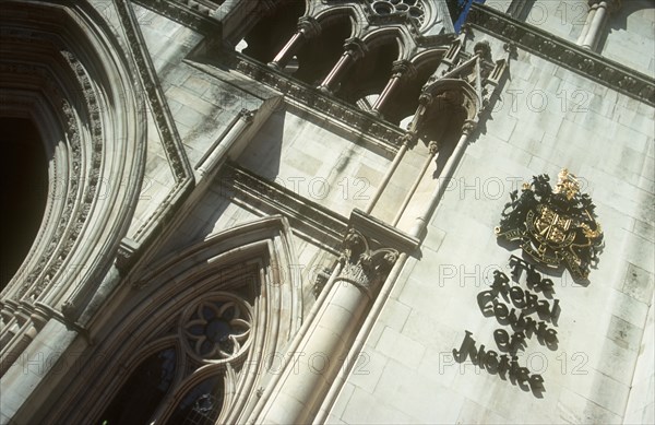ENGLAND, London, Royal Courts of Justice. View looking up at the building with the crest displayed on the wall.
