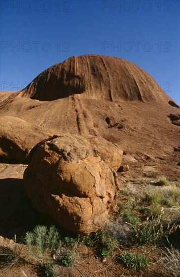 AUSTRALIA, Northern Territory, Uluru, "Ayers Rock, view towards rock with large circular boulder in the foreground."