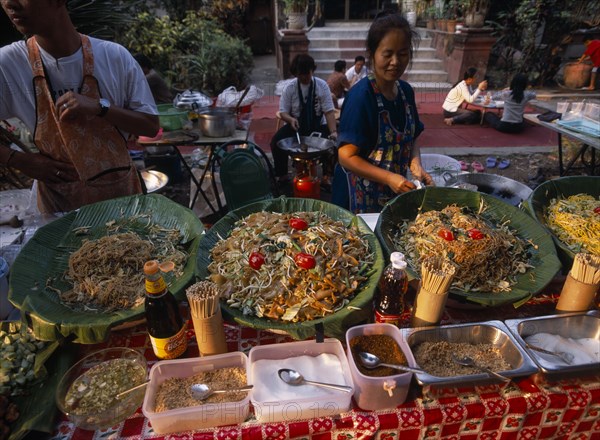 THAILAND, North, Chiang Mai, Wat Chettawan temple grounds with traditional Northern Thai food being served at a stall
