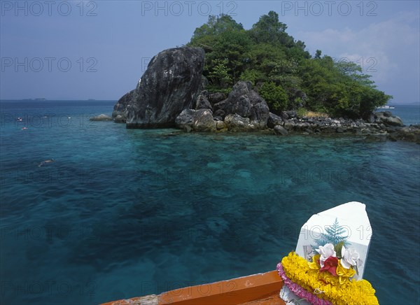 THAILAND, Trat Province, Koh Chang, "Tourists snorkling over coral reefs near Giant Island, Koh Yang, with bow of boat in foreground."