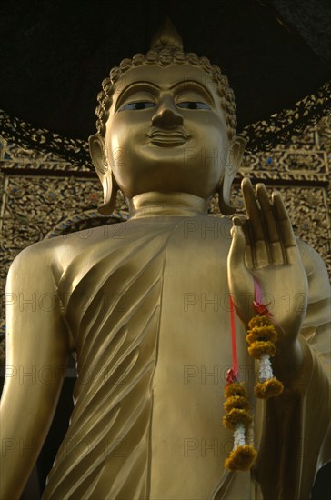 THAILAND, North, Chiang Mai, Wat Bupparam Temple on Tha Phae Road. View looking upwards at face of Golden Buddha statue.