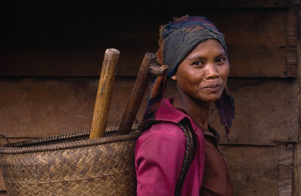 20022935 VIETNAM People Single Women Smiling young woman carrying woven basket on her back  head and shoulders portrait.