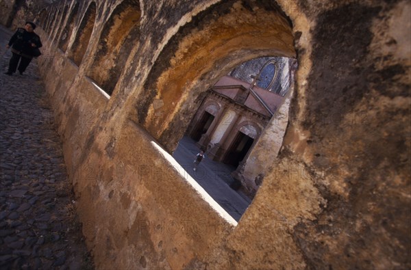 MEXICO, Patzcuaro, Arches and a church with a woman and a boy.