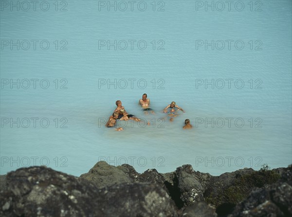 ICELAND, Near Grindavik, Blue Lagoon, Bathers sitting in the hot water rich in natural minerals.