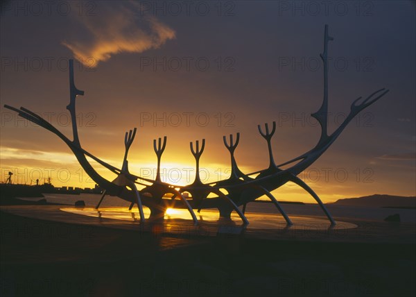 ICELAND, Reykjavik, Sun Voyager or Solfar. 1971 steel Viking ship sculpture by Jon Gunnar Arnason silhouetted at sunset.