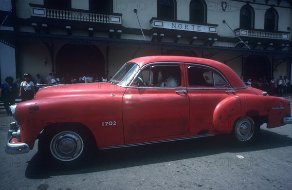 CUBA, Ciego de Avila, Moron, Red 1950 s car being driven in the street