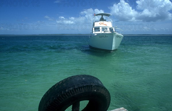 CUBA, Ciego de Avila, Cayo Guillermo, Deep sea fishing boat approaching jetty in clear light blue water