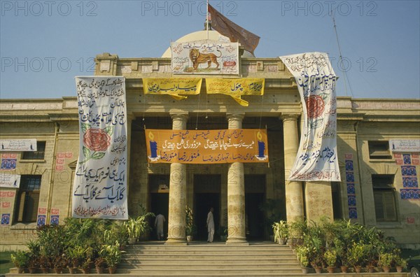 PAKISTAN, Sind , Karachi, Political posters hanging outside columned building entrance