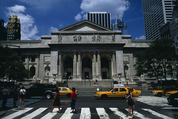 USA, New York , New York City, New York Public Library with pedestrian crossing and yellow cabs in the foreground