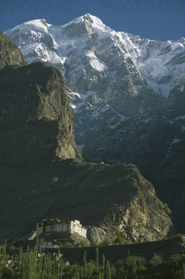 PAKISTAN, Northern Areas, Hunza Valley, "Baltit  Fort built on a cliff side with snow covered peaks of Ultar Sar mountain behind.  Original foundations thought to be 800 years old, restoration completed in 1996."