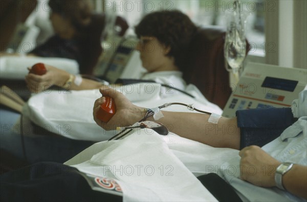 HEALTH, Blood , Men and women donors giving blood with mans arm in the foreground