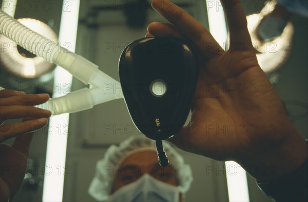 HEALTH, Operation, View looking up toward anaesthetist holding face mask from a patients perspective