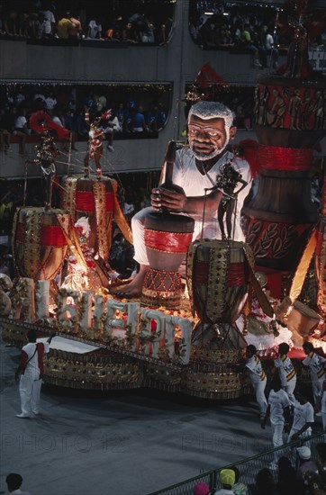 BRAZIL, Rio de Janeiro, Carnival float with large model of a man surrounded by dancers