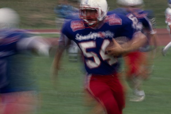 20025666 SPORT Ball Games American Football Blurred action shot of the Brighton B-52s quarter back running with the ball