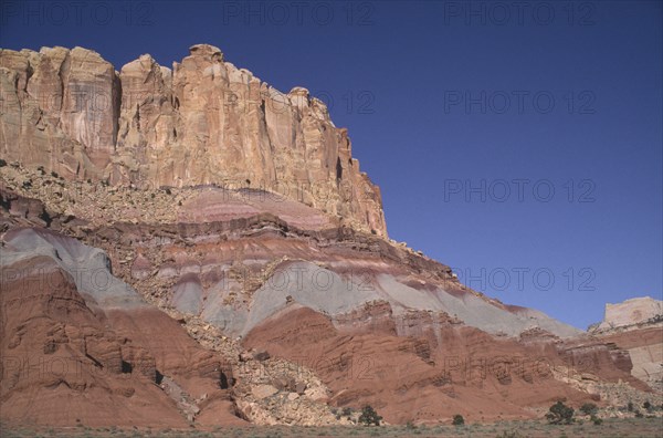 USA, Utah, Capitol Reef National Park. Towering ochre and white and red rock walls displaying sedimentary layers