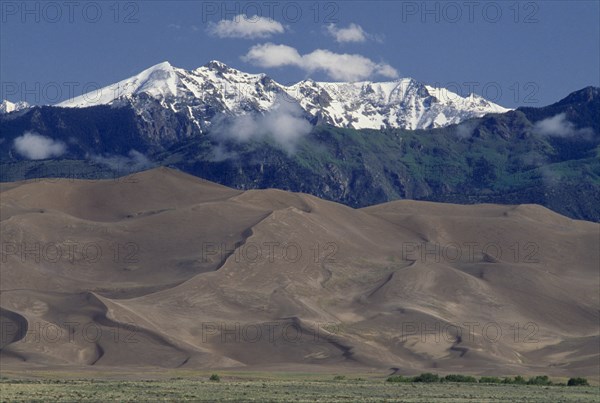 USA, Colorado, Saguache, Great Sand Dunes National Monument. Snow capped mountain landscape behind sand dunes