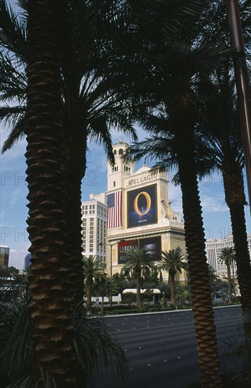 USA, Nevada, Las Vegas, Bellagio hotel sign advertising the ‘ O ‘ water based entertainment show seen through palm trees