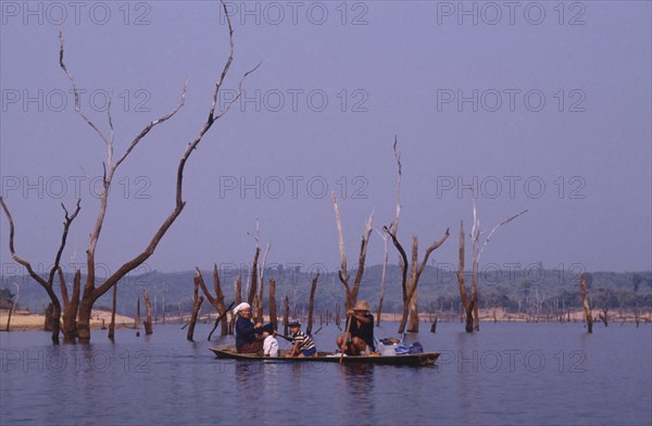 LAOS, Near Talat, Family in a canoe on a lake in a flooded valley