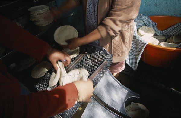 MEXICO, Mexico City, Preparation of tortillas at tortilla bakery or Tortilleria.  Cropped view of people at work.